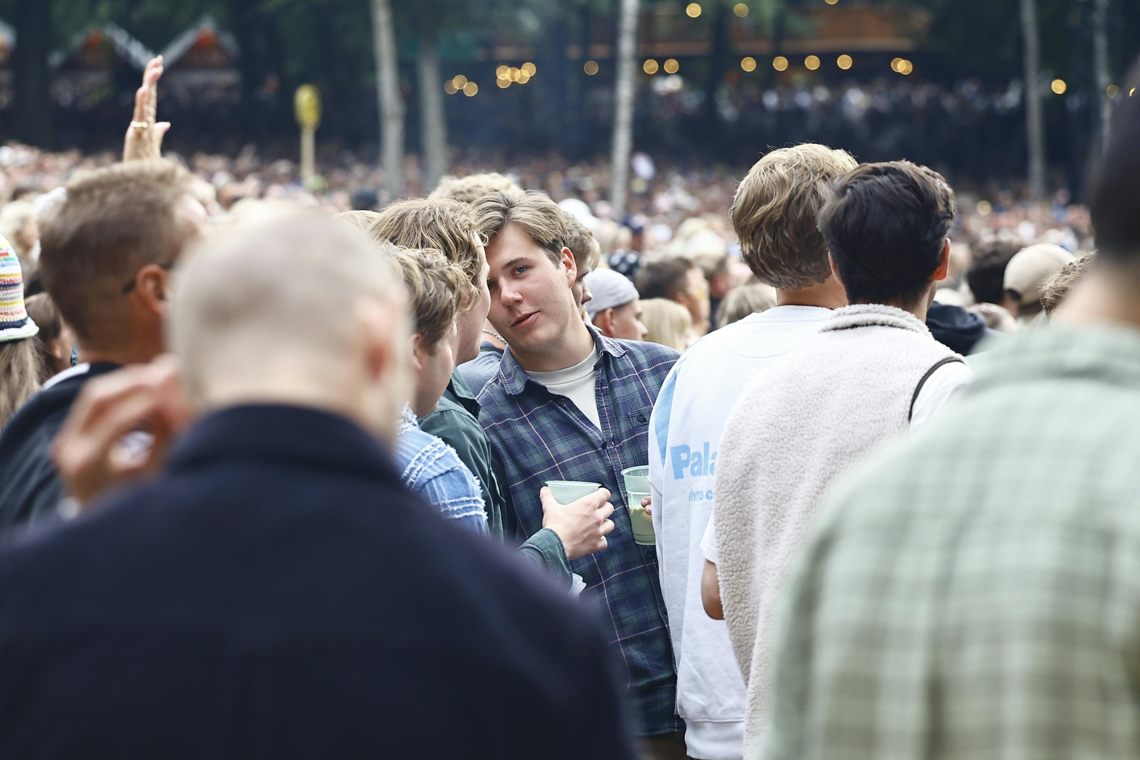 Kronprins Christian hygger sig på festival med en drink.