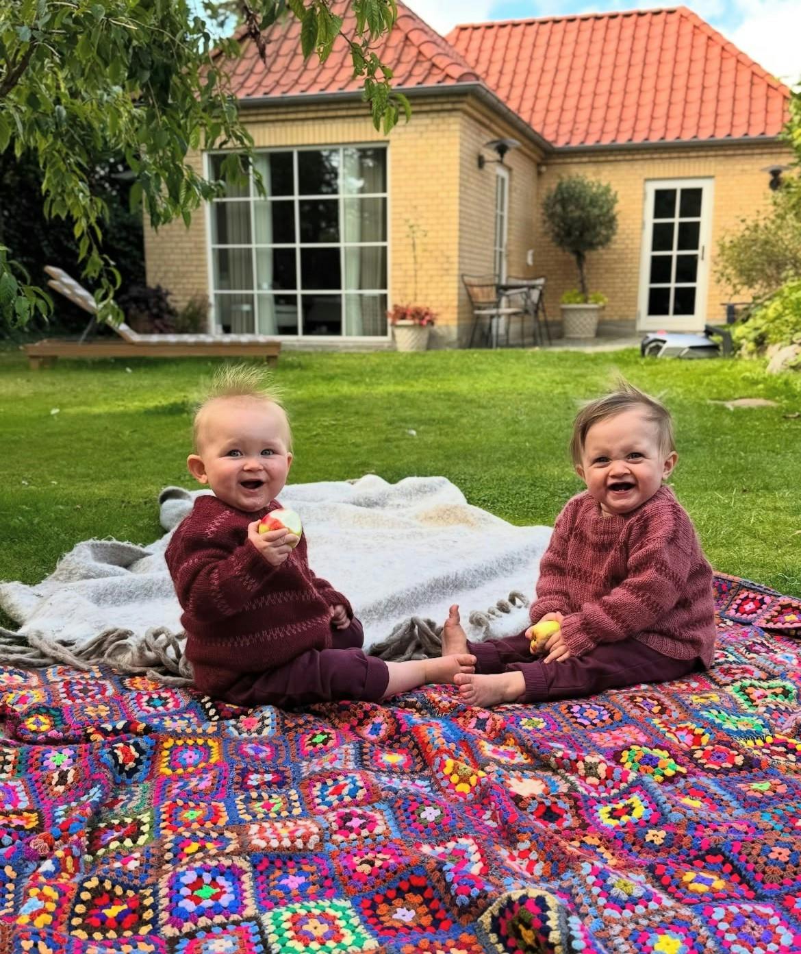 Tvillingerne Nora og Emma hygger med æbler.