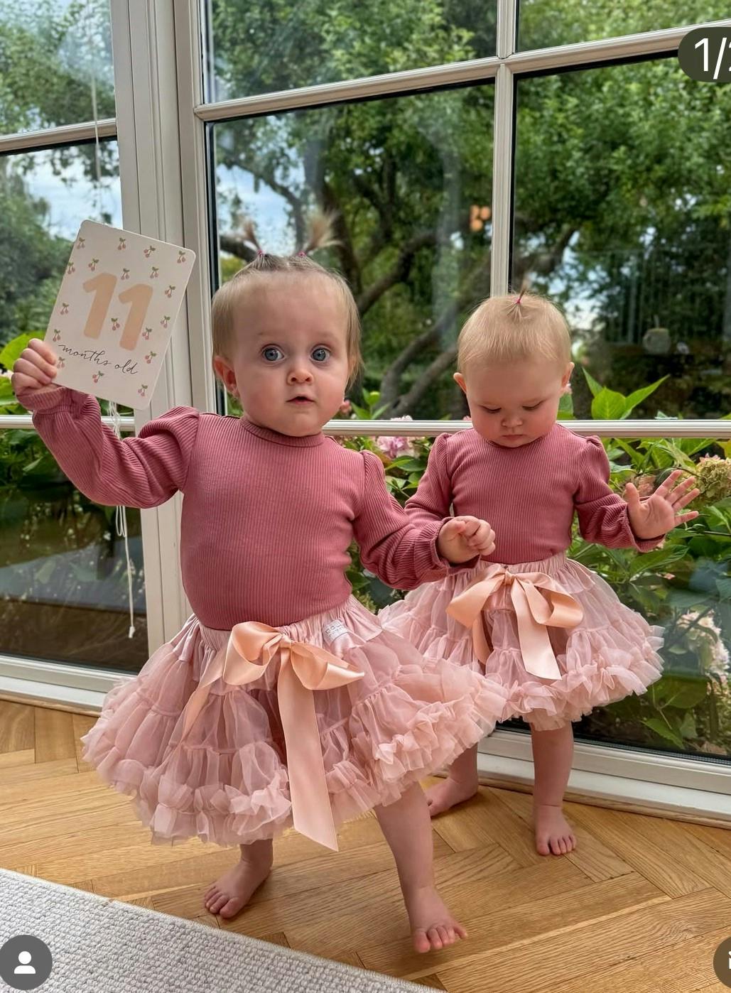 Emma med fødselsdagskortet i hånden og tvillingesøster Nora lige bag ved.