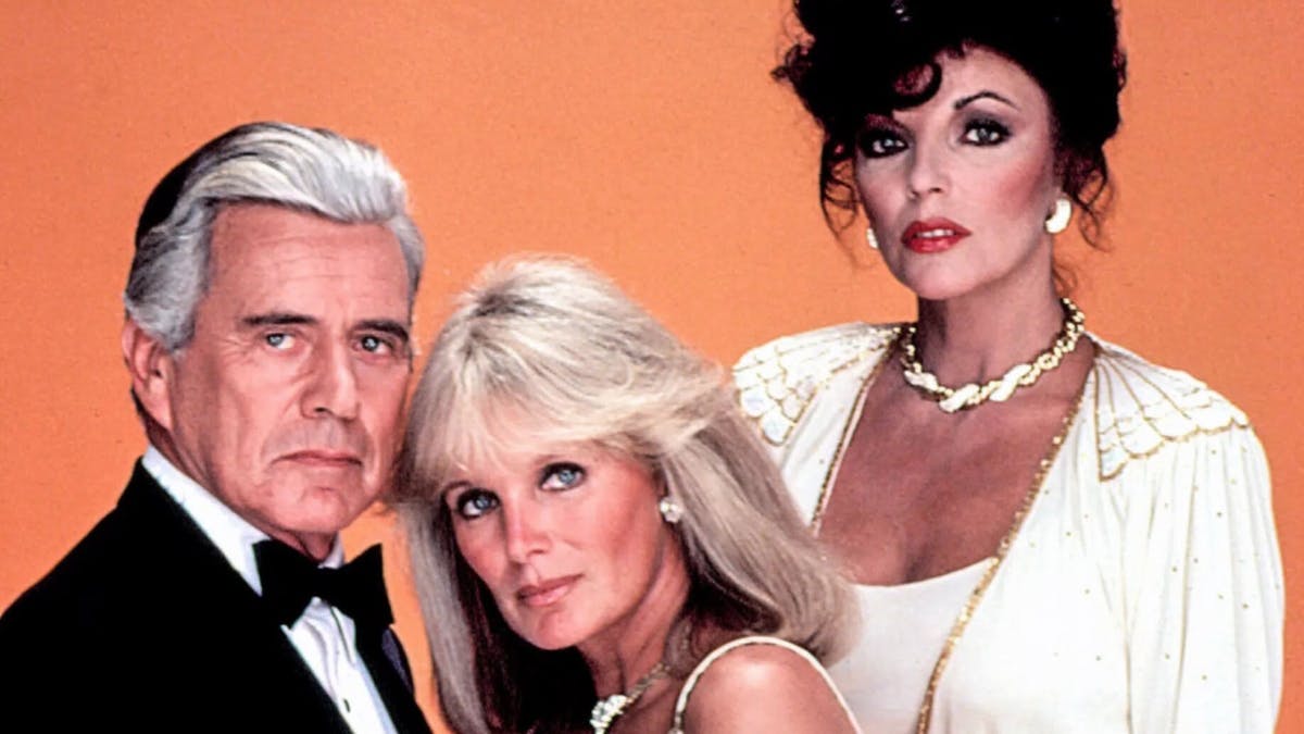 Linda Evans og Joan Collins med John Forsythe, der spillede Blake Carrington i Dollars.&nbsp;