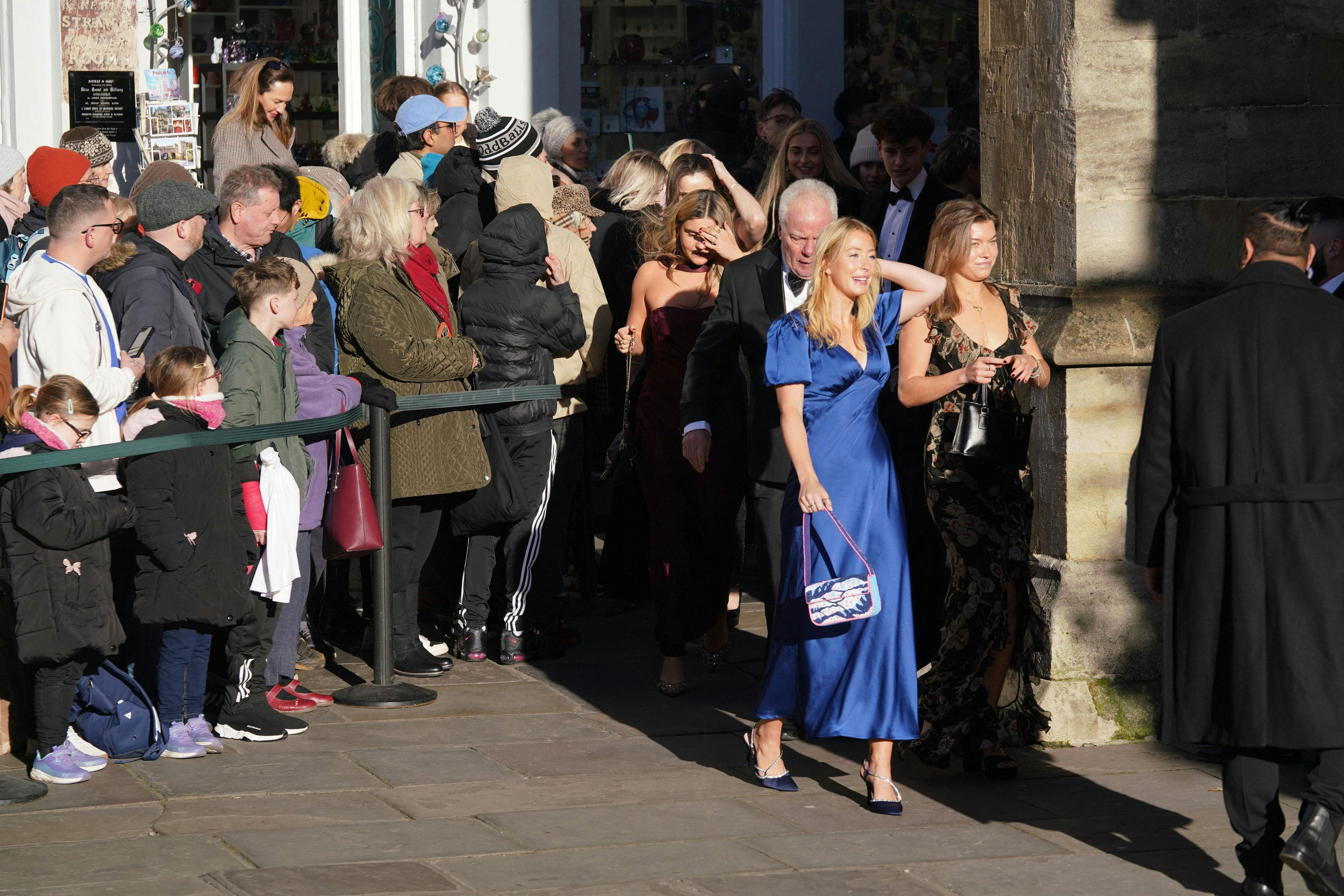 Folk har samlet sig foran kirken, hvor gæsterne ankommer.