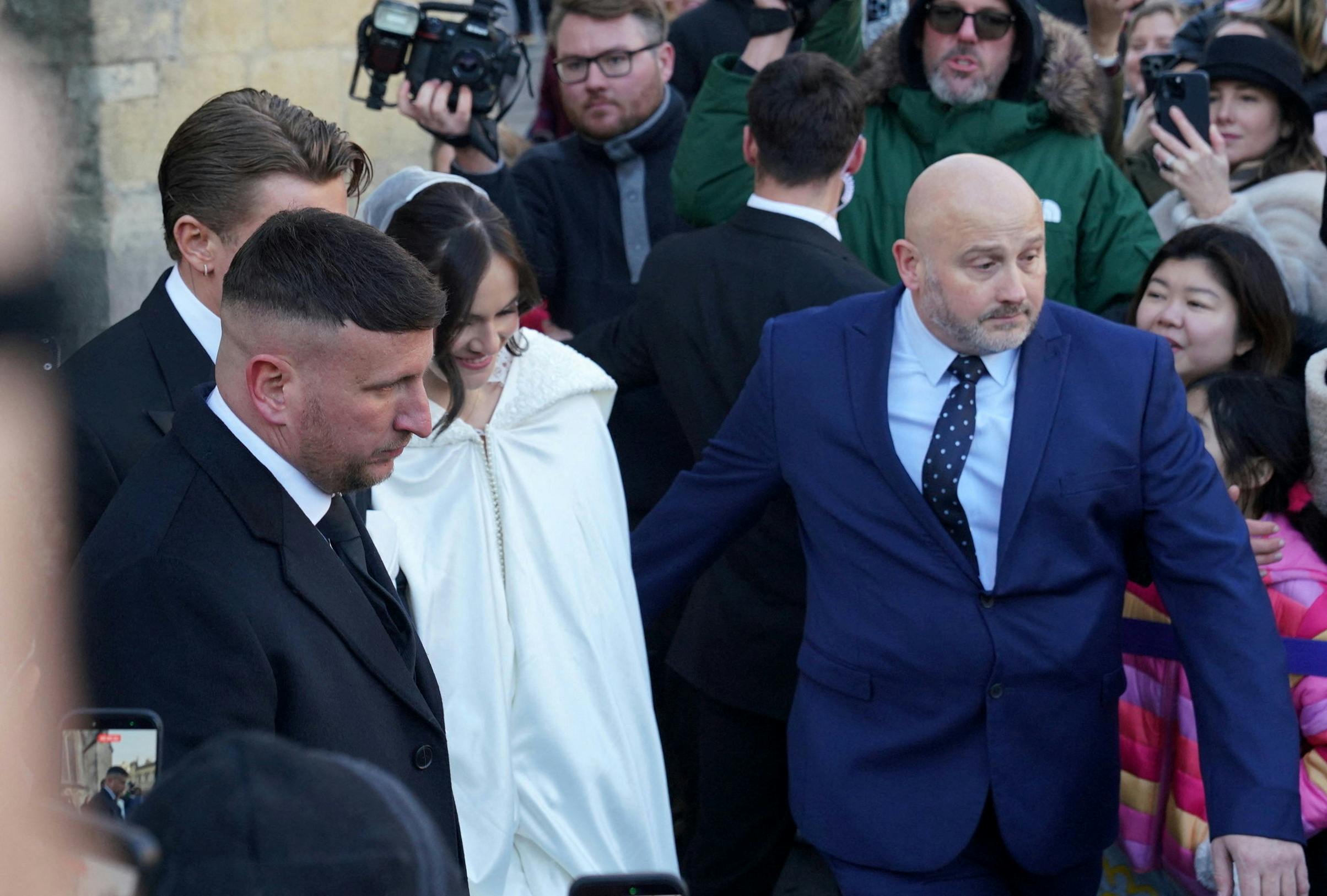 Adam Peaty og Holly Ramsay på bryllupsdagen den 27. december i Bath. Gommen kan lige anes bag ved den forreste bodyguard i billedet. 