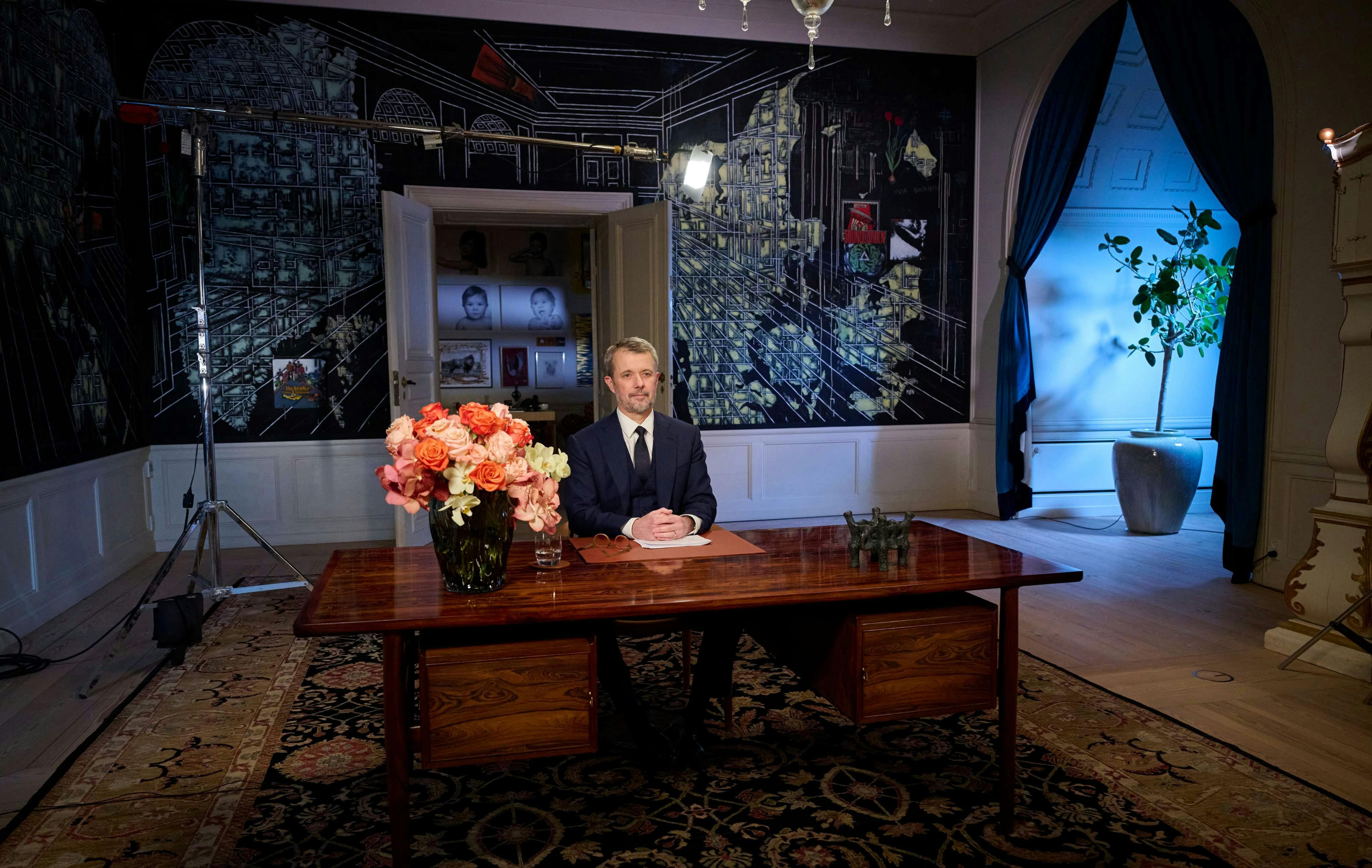 Kong Frederik i modtagelsesgemakket i Frederik VIII's Palæ på Amalienborg, hvor han holdt nytårstale 31. december 2025. I baggrunden ses blandt andet billeder af prins Vincent og prinsesse Josephine. 