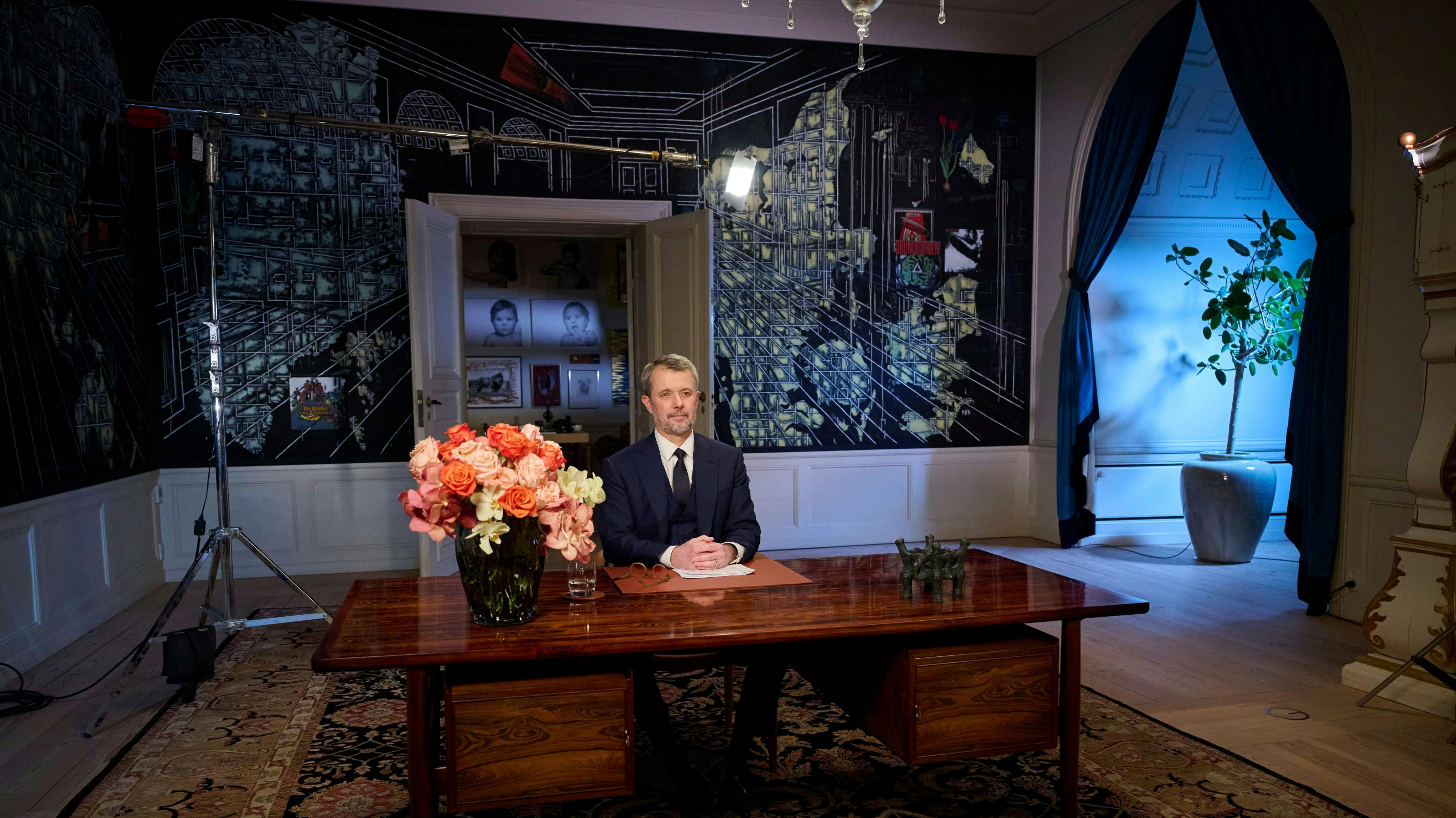 Kong Frederik i modtagelsesgemakket i Frederik VIII's Palæ på Amalienborg, hvor han holdt nytårstale 31. december 2025. I baggrunden ses blandt andet billeder af prins Vincent og prinsesse Josephine.