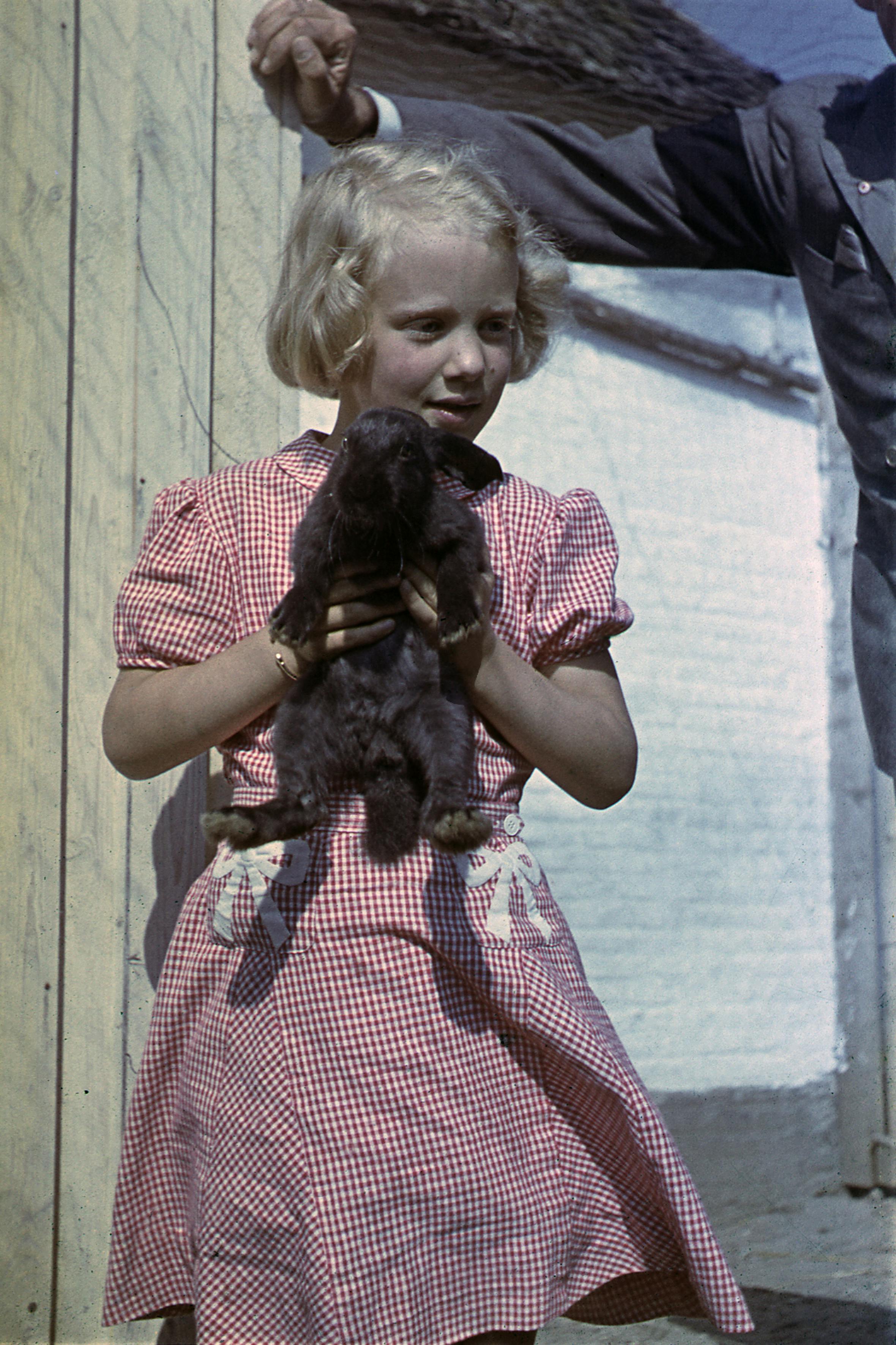Kong Frederik IX og dronning Ingrid på sommerferie i 1948 med de tre små prinsesser. Her ses prinsesse Margrethe med en sort kanin. 