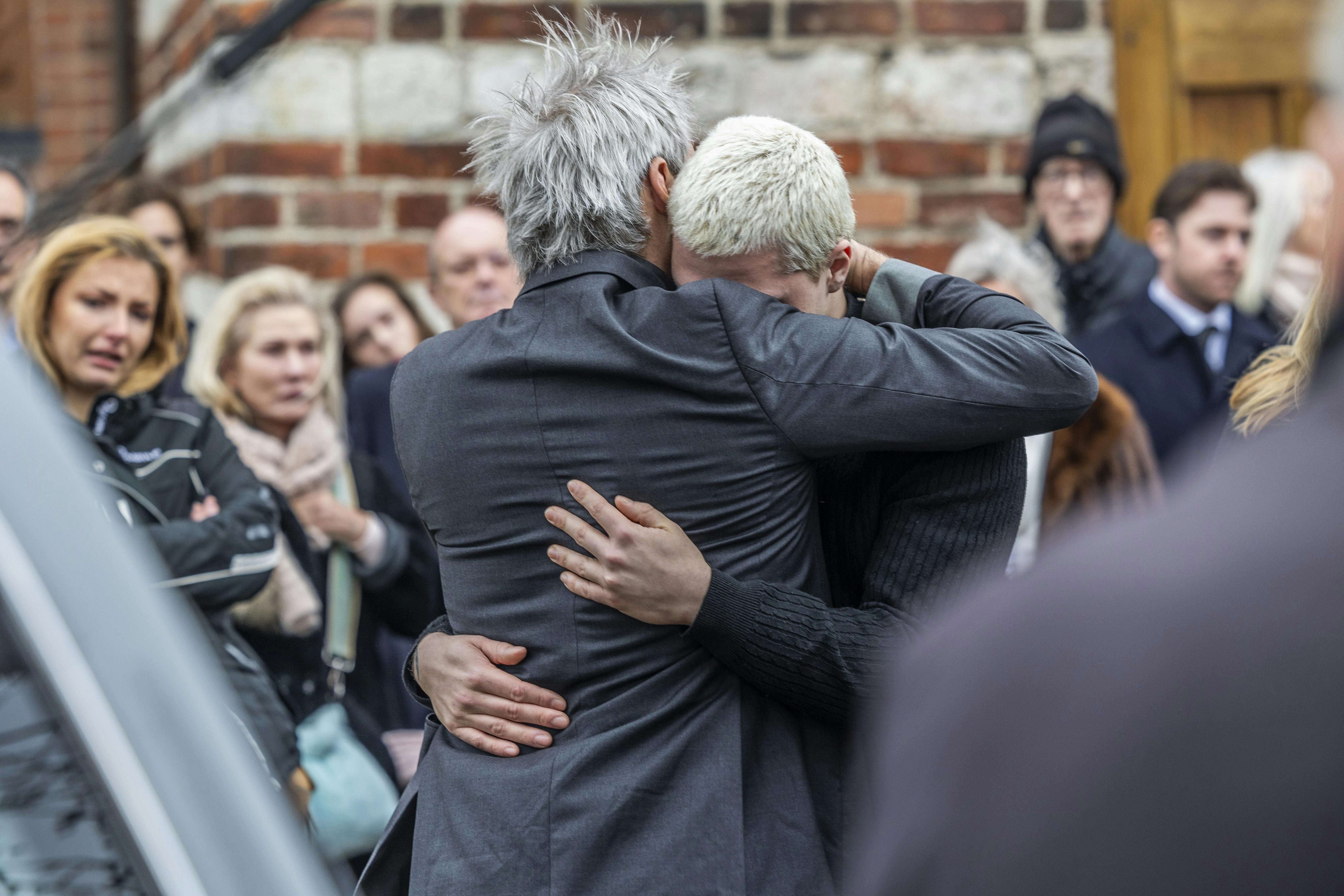 Oliver og Oscar Bjerrehuus i et trøstekram foran Gentofte Kirke.