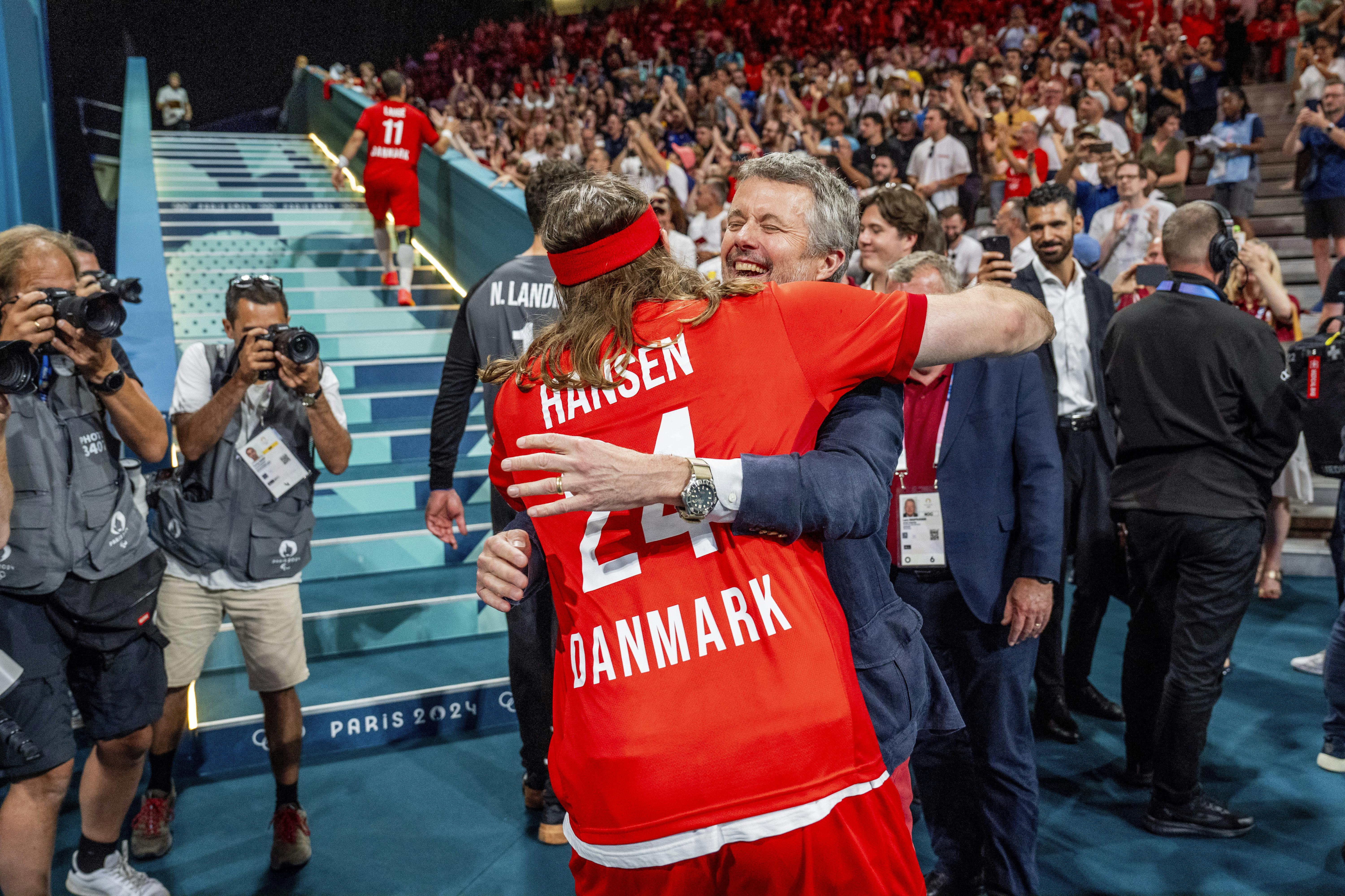 Kongefamilien har i mange år fulgt de danske håndboldherrer. Her får kong Frederik en ordentlig krammer efter OL-sejren i 2024.