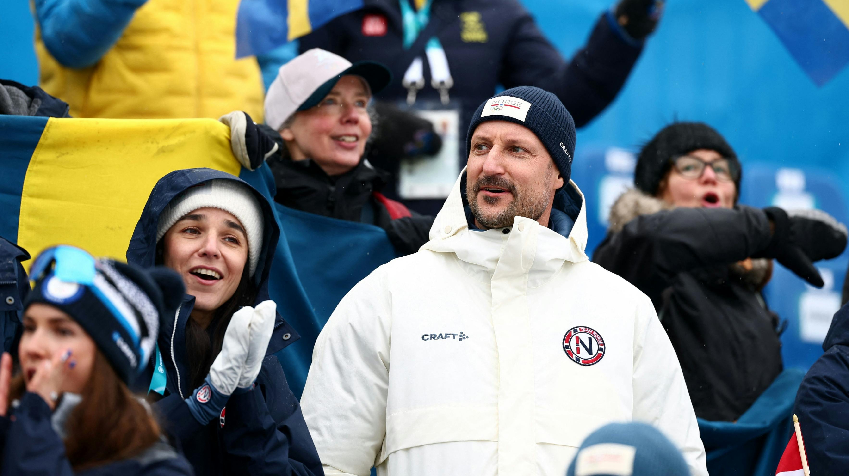 En prominent kvinde sidder ved siden af kronprins Haakon. 