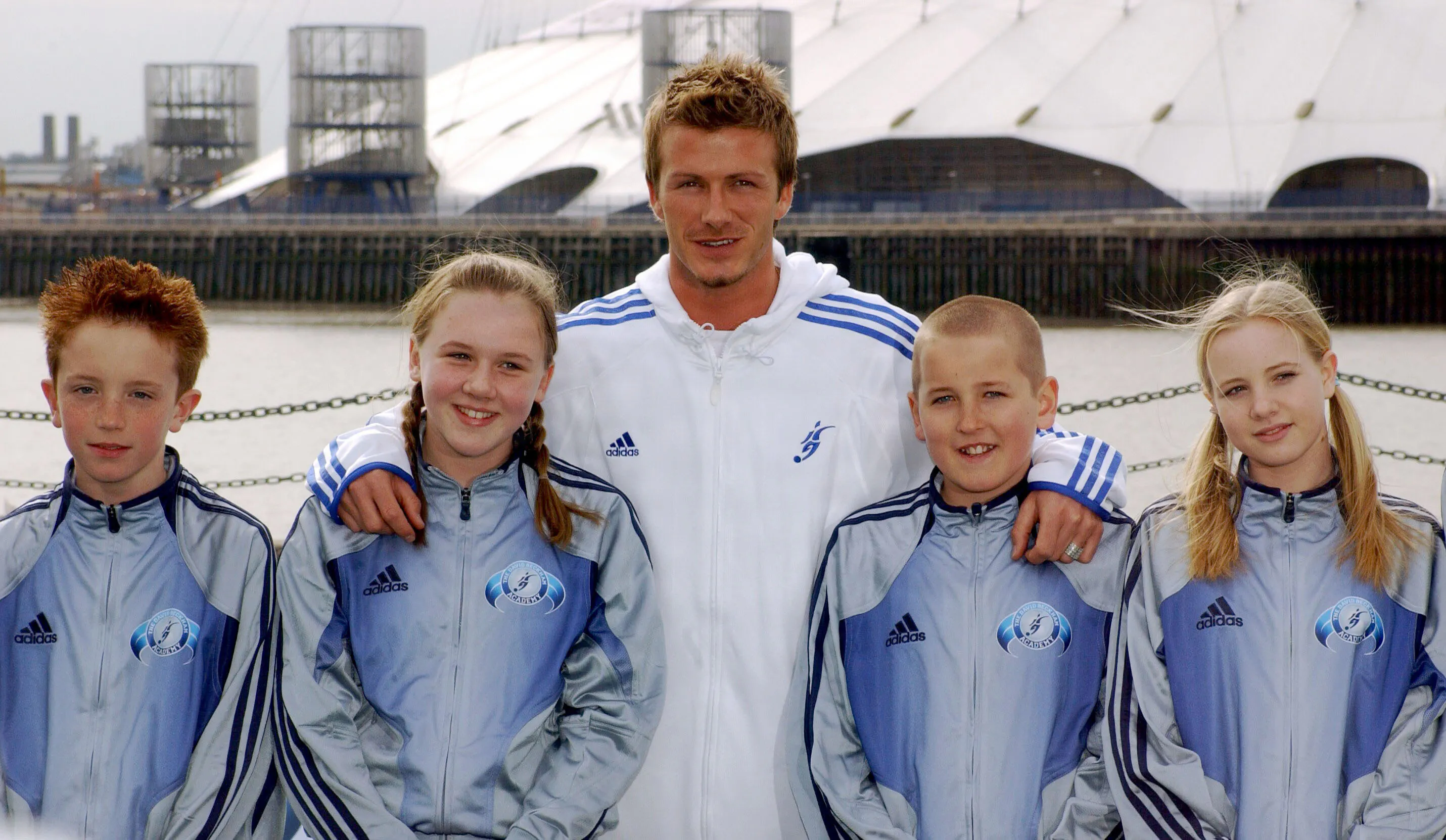 David Beckham med den ene arm om Harry Kane (med det karseklippede hår) og den anden om Katie Goodland.