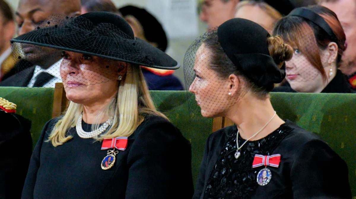 Dronning Mette-Marit i tårer med sin datter ved sin side.
