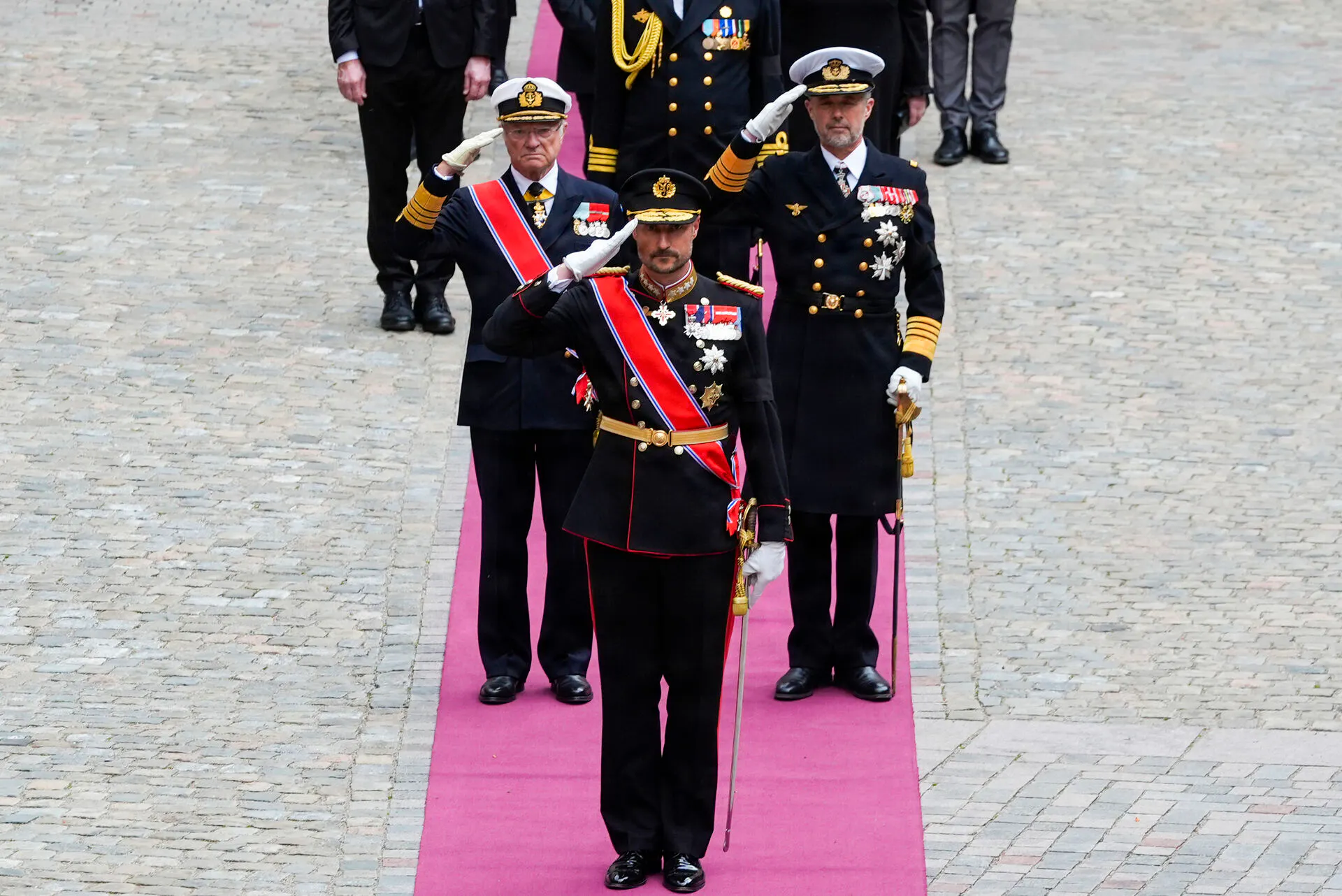 Kong Carl Gustaf, kong Haakon og kong Frederik foran Akershus Slotskirke. 