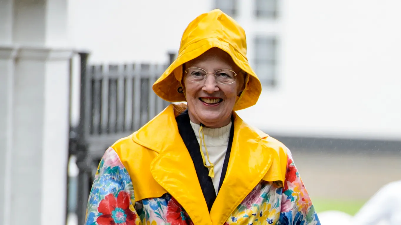 Dronning Margrethe i sin blomstrede regnfrakke og gule sydvest er nok et af hendes mest ikoniske looks. Her er hun fotograferet ved Graasten Slot i 2017.
