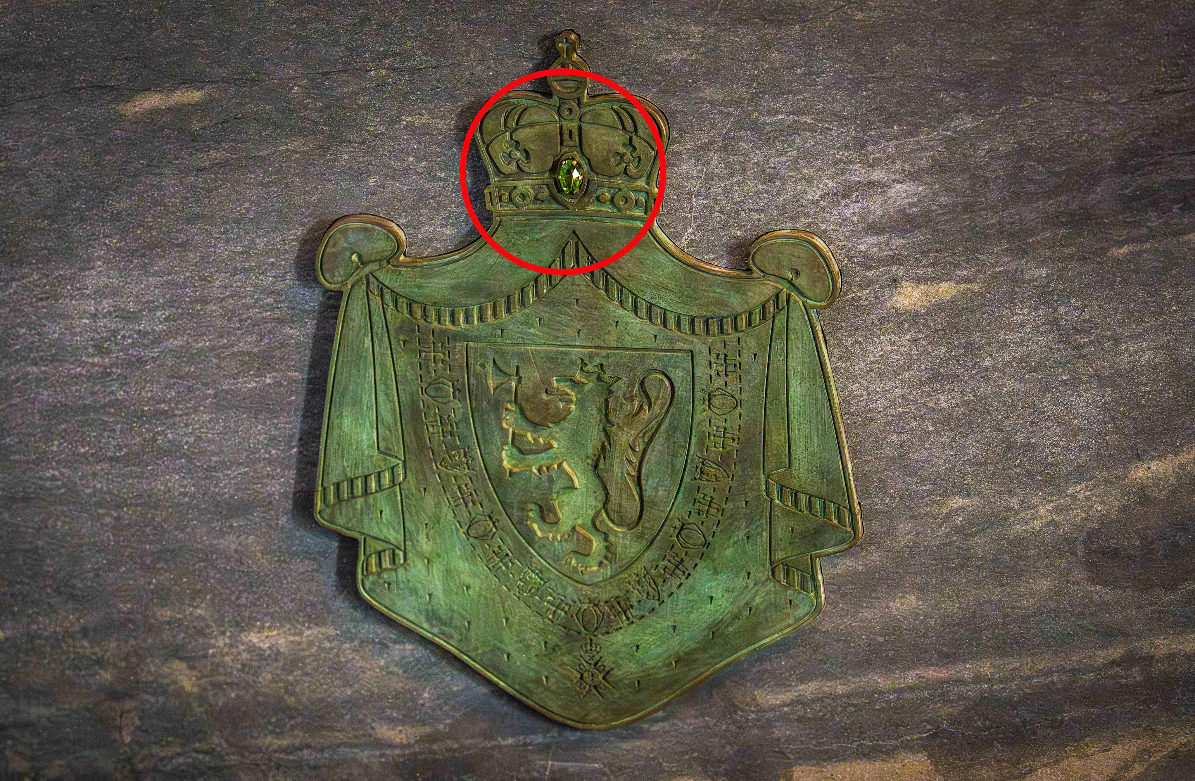 Detalje fra kong Harald og dronning Sonjas sarkofag i Akershus Slottskirke. I den røde cirkel ses den grønne peridot-sten.