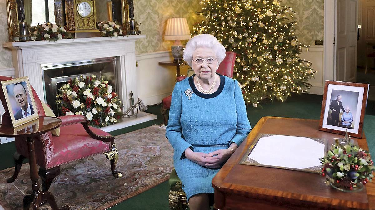 Dronning Elizabeth holdt sin tale fra det såkaldte Regency-gemak på Buckingham Palace - men fotos af sin søn, prins Charles, og gemalen, prins Philip, omkring sig.