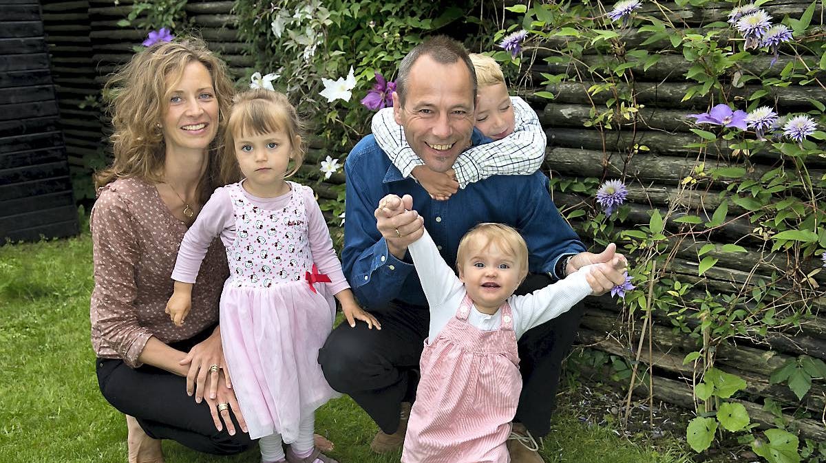 Mikael hjemme i haven i Valby med sin hustru, Heidi Vestergaard Nielsen, og børnene Ada (forrest), Noomi og Isak om halsen på far.