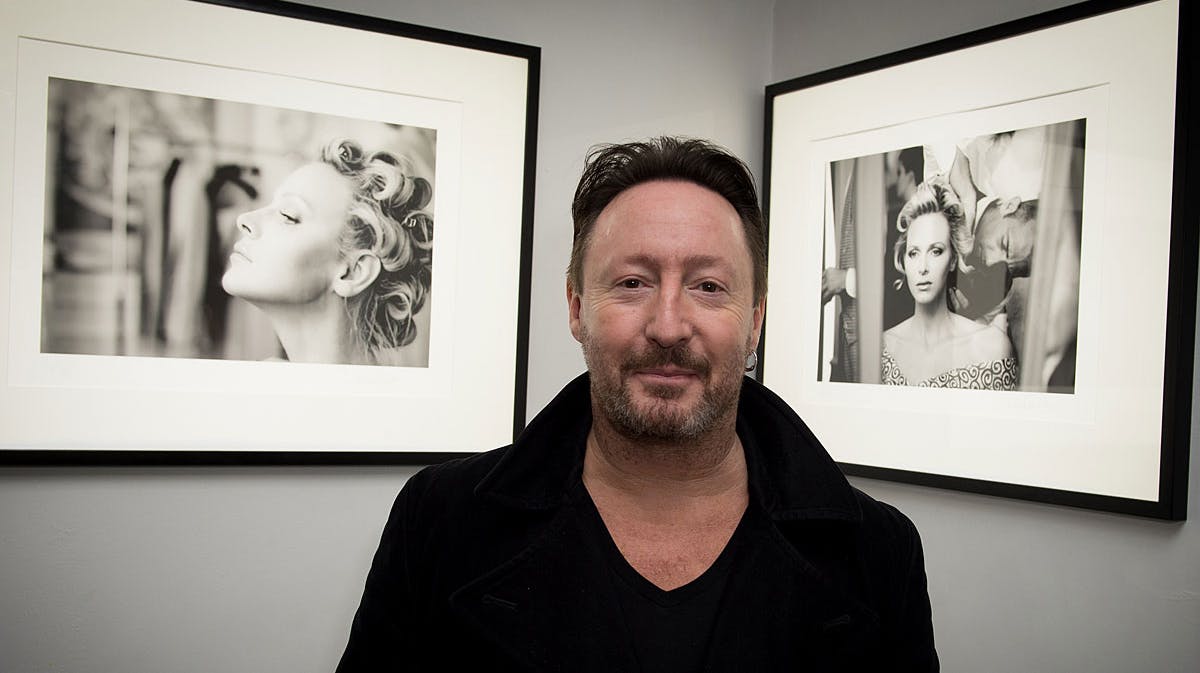 Julian Lennon med nogle af portrætter af fyrstinde Charlene i baggrunden.