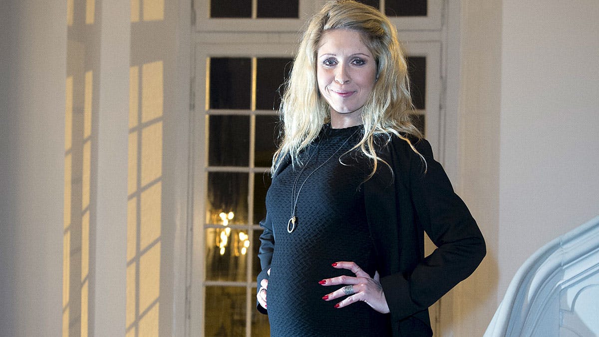 Karian Frimodt viser stolt sin gravide mave frem
