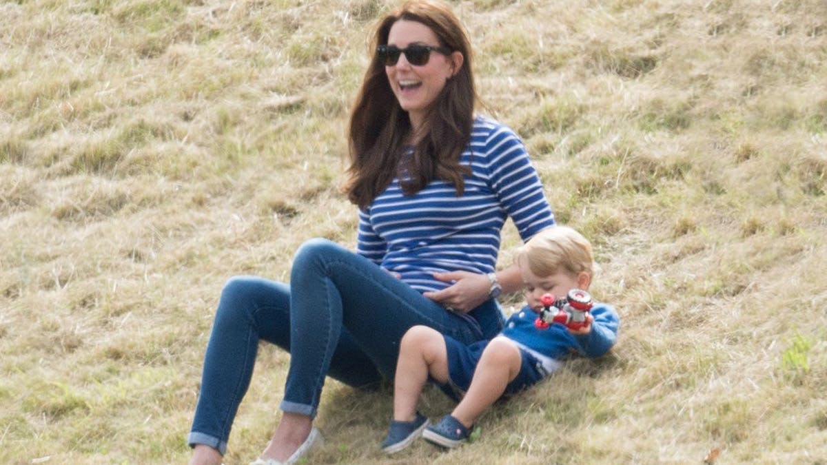 Prins George tumler i græsset med sin mor, hertuginde Catherine af Cambridge.
