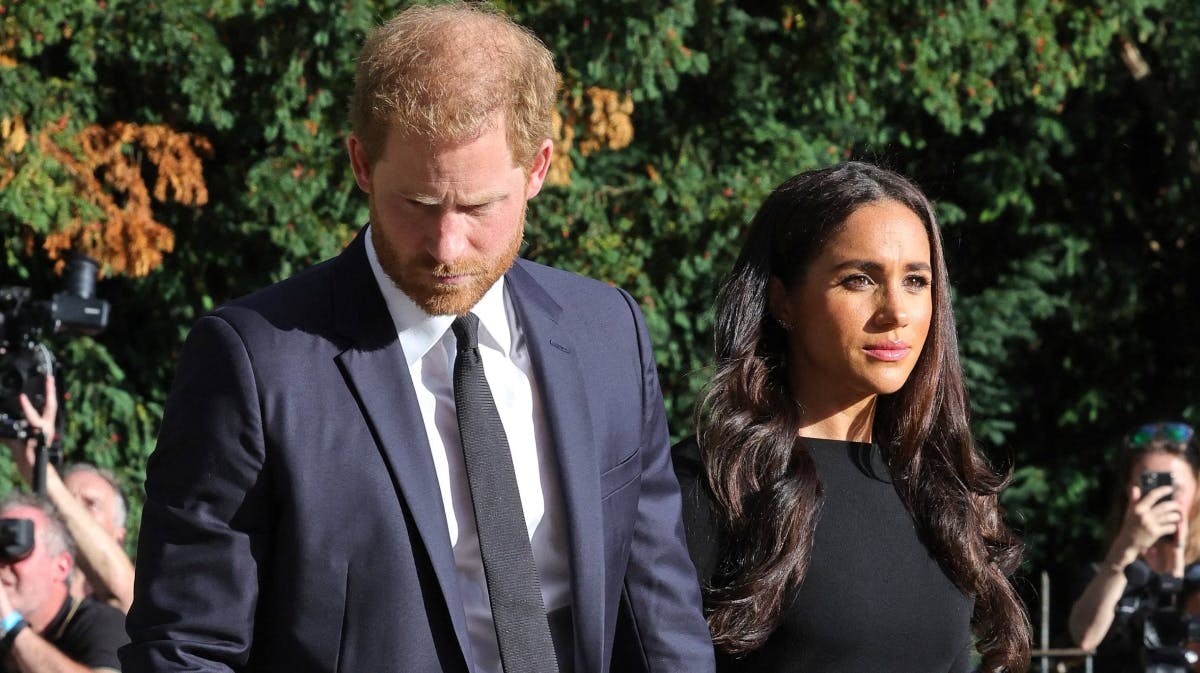 Prins Harry og hertuginde Meghan ser på blomster lagt til ære for afdøde dronning Elizabeth.