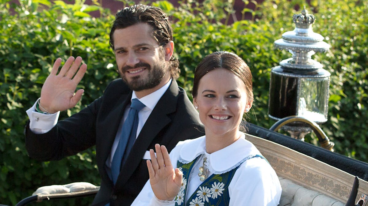 Prins Carl Philip og prinsesse Sofia vinker fra kareten på nationaldagen.