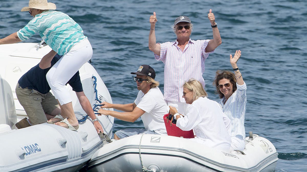 Et glad kongepar vinker til fotografen under deres ferie i St. Tropez.