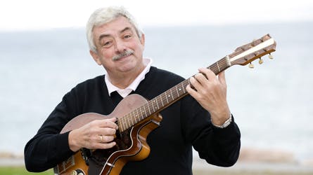 johnny reimar spiller guitar på stranden