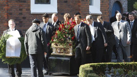 Den tunge kiste blev båret ud af kirken af seks mand, heriblandt Flemming Flindts to svigersønner. Til venstre den store krans fra dronningen. Flemming Flindt ligger nu begravet på Frederiksberg Kirkegård, hvor også hans forældre og bror har et gravsted.