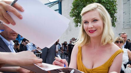 Kirsten Dunst skriver autografer i Cannes.