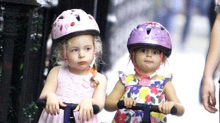 Søde små tvillingepiger - Marion Loretta og Tabitha Hodge - i New Yorks gader med hver deres pink cykelhjelm.