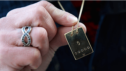 Tinas fødselsdagsgave fik følelserne frem hos Allan, der her viser ?hundetegnet? med lykketallet ?5? og fem sorte diamanter, der matcher stenene i forlovelsesringen.
