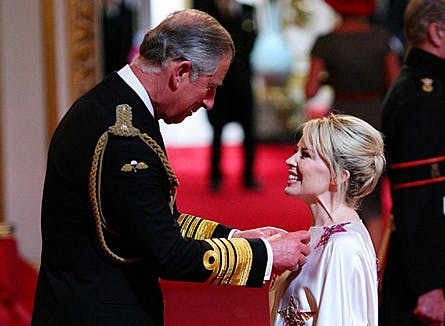 Den australske sangfugl Kylie Minogue storsmilede mens prins Charles påførte den britiske orden OBE.
