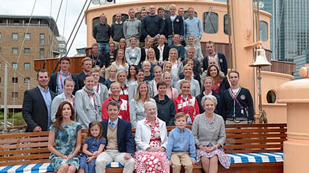 Kongefamilien samlet på gruppebilledet med flere af de danske OL-atleter på kongeskibet Dannebrog i London.