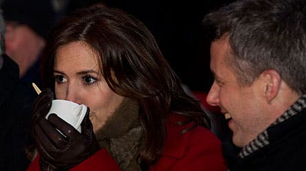 Det er koldt i Kina - det ses tydeligt på dette billede af kronprinsesse Mary, der skutter sig med lidt varm gløgg mens kronprins Frederik muntert ser til.