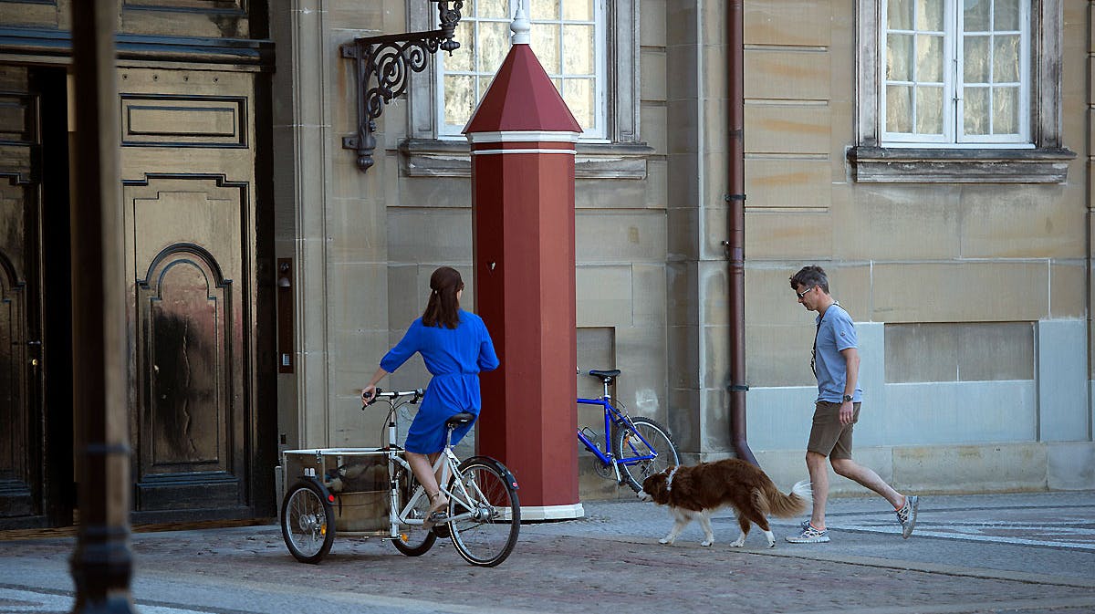 Arkivfoto: Kronprinsesse Mary på cykel sammen med kronprins Frederik og hunden Ziggy på vej ind i boligen på Amalienborg med skilderhus foran.