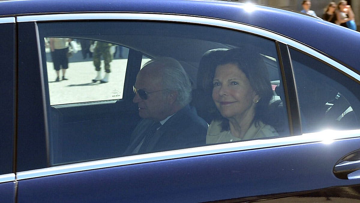 Dronning Silvia og kong Carl Gustaf i bil ved slottet